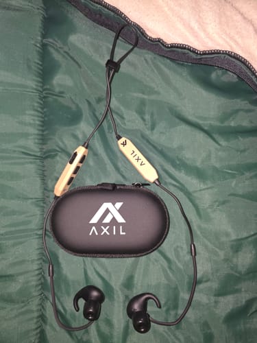 Customer's GS Extreme 3.0 earbuds and black branded case resting on a green quilted surface.