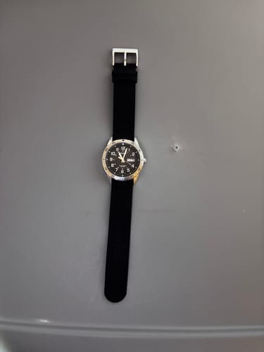 Reviewer's black CanvaSoft 2.0 strap fitted on a silver Casio watch, laid flat on a gray surface.