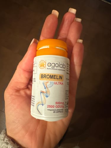 Recensore che tiene in mano il piccolo flacone di Bromelin Ultra.