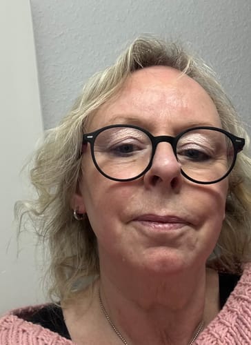 Kundin in Nahaufnahme, die einen rosa Strickpullover trägt, der das Überraschungsgeschenk war.