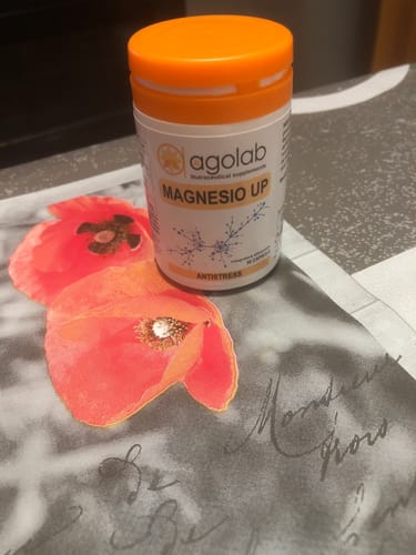 Recensore mostra il flacone bianco di Magnesio UP con il tappo arancione.