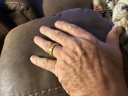 Customer's hand wearing the gold Aureum ring, highlighting the textured foil inlay.