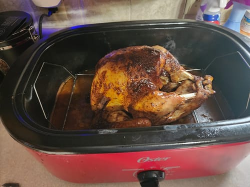 Customer's roasted turkey in a red roaster after using the Turkey Brine Kit.