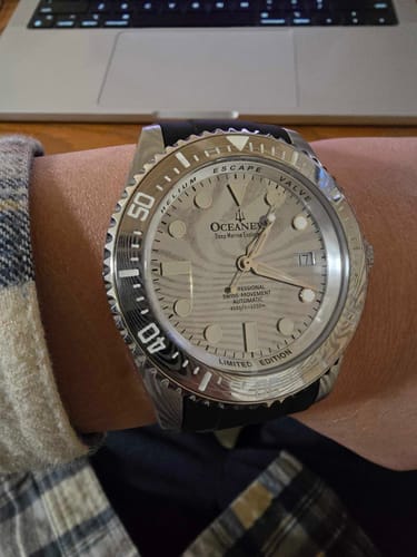 Customer's Oceaneva Deep Marine Explorer II watch with a silver Damascus steel dial shown on their wrist.