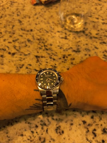 Customer wearing the Oceaneva Deep Marine Explorer II watch on their tattooed wrist.
