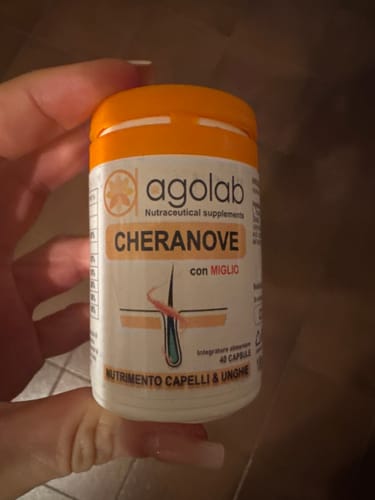 Cliente che mostra da vicino il flacone di Cheranove, un integratore per capelli e unghie.