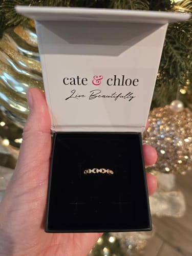 Reviewer holding the open Cate & Chloe gift box showing the elegant Paula Chain Link Ring inside.