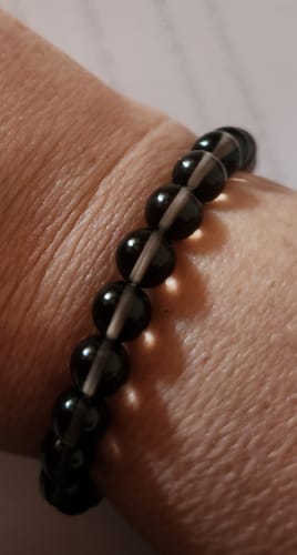 Gros plan du bracelet en quartz fumé porté au poignet par un client.