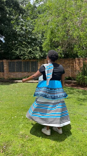 Reviewer from behind twirling in the Ankara Pleated African 3 Piece Skirt, showing the striped pattern against a black shirt.