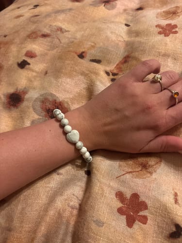 Customer's wrist showing a beaded howlite bracelet with a lovely heart-shaped stone.