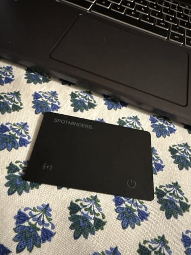 Reviewer's black SPOTMINDERS Tracking Card on a patterned surface in front of a laptop.