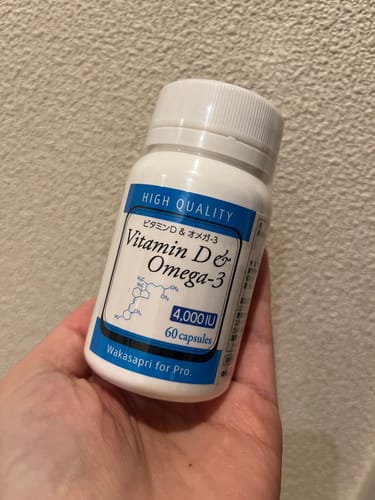 レビュー投稿者が、「高濃度ビタミンD＆オメガ-3」の白いボトルを手に持っている様子。