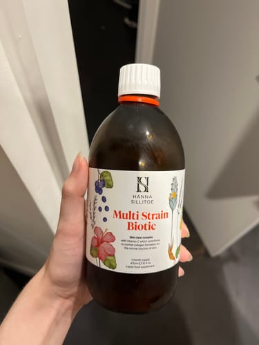 Customer holding a brown bottle of Multi Strain Biotic, showing the front label.