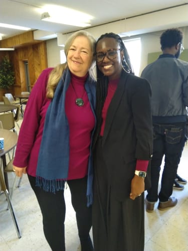 Customer wearing black Frost Duralite® Leggings styled with a magenta turtleneck and blue scarf indoors.