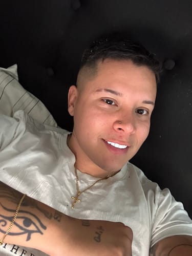 Un cliente sonriendo mientras lleva puesta la Cadena Fígaro Oro de 3mm.