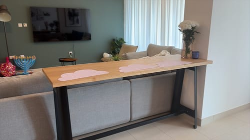 Customer's Industrial Long Bar Table with a natural top, placed behind a grey sofa in a modern living room.
