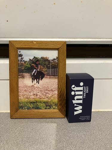 Customer's dark blue Twilight Envy box on a counter next to a framed photograph.