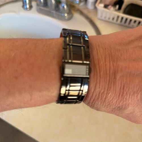Reviewer shows the Paladin M109A7 Howitzer bracelet fitted on their wrist in a bathroom.