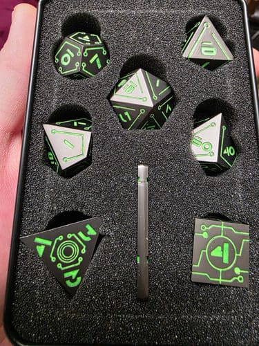 Customer's black Cyberlink dice set with neon green circuit designs shown inside its storage tin.