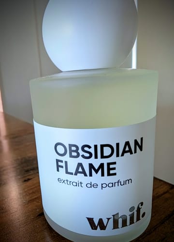 Customer's frosted glass bottle of Obsidian Flame perfume, with its large spherical cap.