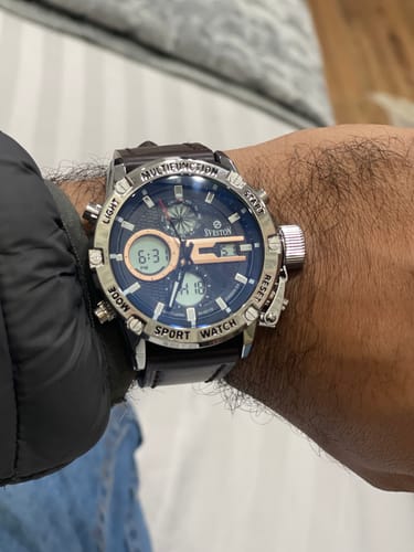 Customer wearing the Zoddok 1.0 watch, showing the large silver case, blue multifunction dial, and dark leather strap on their wrist.