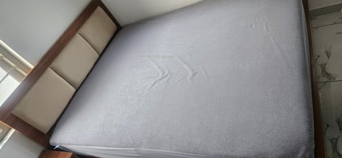 Reviewer's light grey Flo mattress protector fitted neatly on a double bed.
