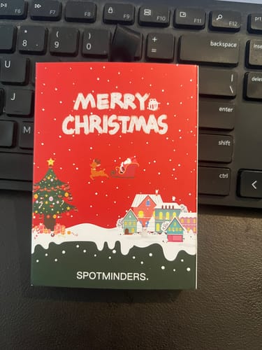 Customer's SPOTMINDERS. Tracking Card box with a festive 'Merry Christmas' design on a keyboard.