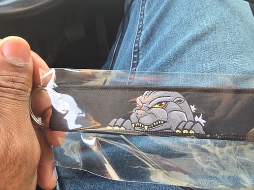 Reviewer holding the embroidered GOJIRA JET TAG in its original clear packaging.
