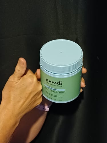 Customer gives a thumbs-up while holding the green tub of Lemon Lime pre/probiotic blend.