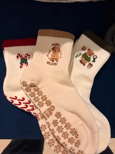 Customer's three pairs of festive Candy Christmas socks, showing embroidered designs and non-slip grips on the soles.