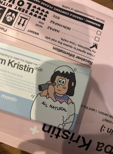 レビュー投稿者による、「I am Kristin - グレー」の製品パッケージ。ピンクの配送用封筒の上に置かれています。