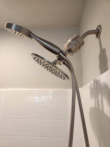Customer's close-up of the installed dual shower head set, showing the brushed metal filter, rain head, and handheld sprayer.