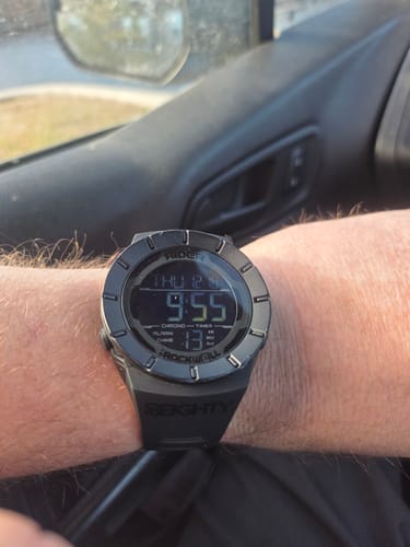Customer's black Rockwell Coliseum Watch on their wrist. The durable watch shows some minor scuffs around the digital display.
