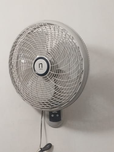 El ventilador de pared Navia de un cliente instalado en una pared blanca.