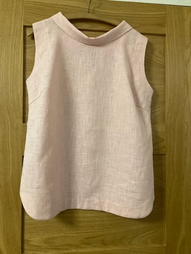 Customer's sleeveless top made from light pink Washed Linen Blend Fabric, showing the front view on a hanger.