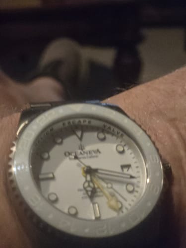 Customer's close-up of the Oceaneva GMT Titanium watch on their wrist, showing the white dial and white ceramic bezel.