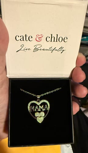 Customer holds open the white gift box, revealing the sparkling Selena Mama Heart Pendant Necklace inside.