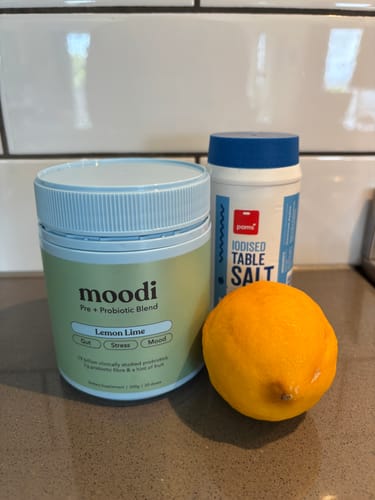Customer's tub of Moodi Lemon Lime sits on a counter with a lemon and salt, ready to make a 'Moodi-rita'.