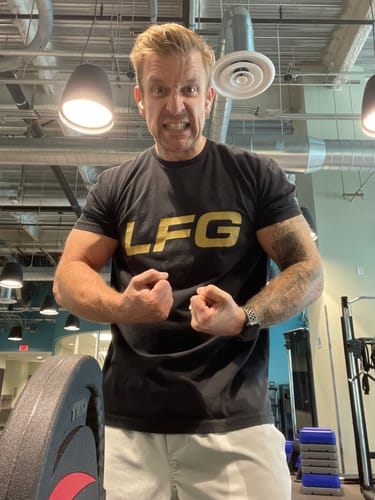 Customer with an intense expression flexing muscles in a gym, in a review for V1X PRODIGY pre-workout.
