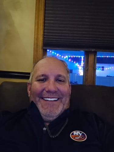 Reviewer giving a broad smile, showing their white and even Pop On Veneers.