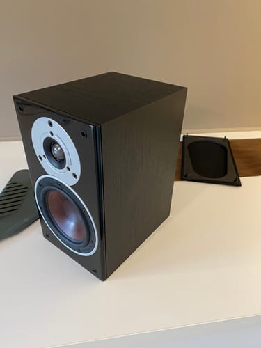 Anmelderens svarte høyttaler på et bord før påføring av Walnut Deep kontaktplast.