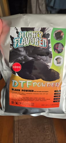 Reviewer holding the Highly Flavored DTF Black Powder 500g bag.