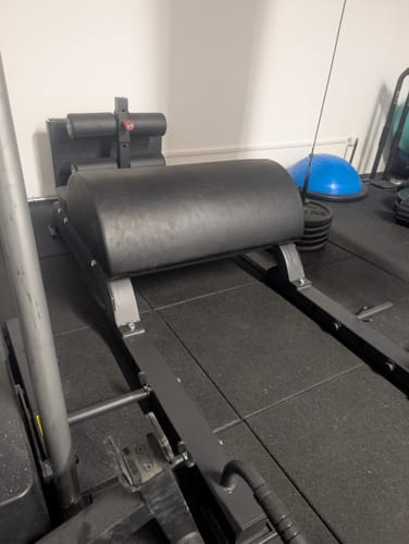 Customer's black Floor Glute Ham Developer machine assembled in a home gym on a black tiled floor.