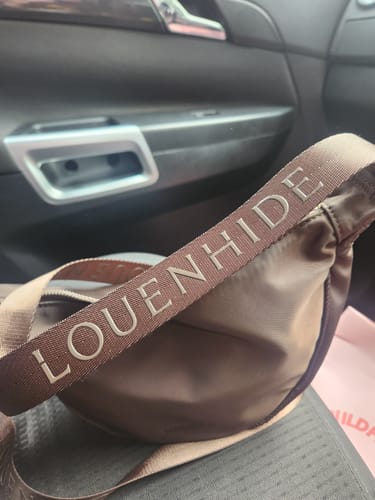 Customer's close-up of the chocolate Sylvia Nylon Crossbody Bag, highlighting the branded sateen webbing strap.