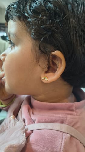 Customer showing a close-up of a child wearing the Golden Rainbow Kids Studs.