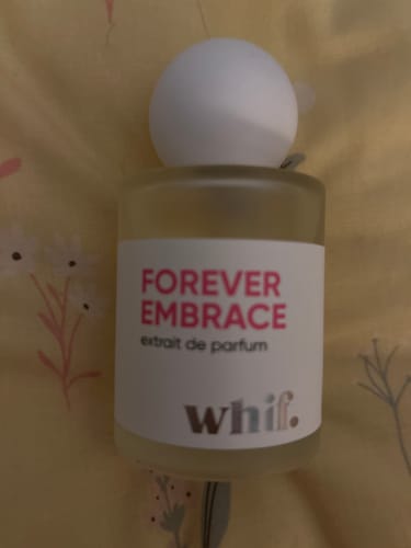 Customer's Forever Embrace perfume bottle, highlighting its white cap and pink lettering.