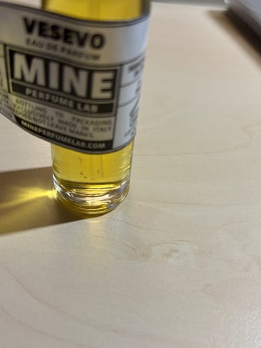 Recensore mostra l'etichetta storta e scollata su un campione di profumo.