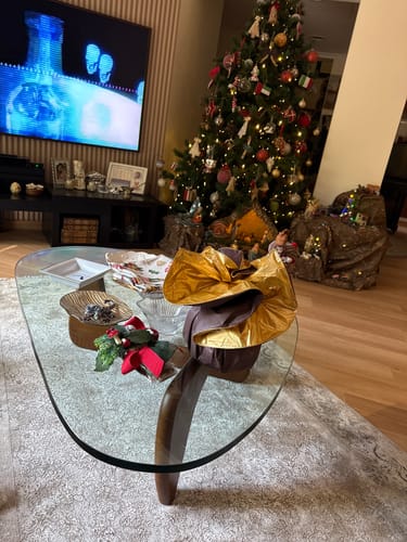 Customer's Noguchi solid wood coffee table with a glass top in their festively decorated living room.
