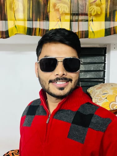 Reviewer smiling while wearing the Co-Pilot black and silver Wayfarer sunglasses indoors.