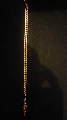 Customer's gold Box Chain Bracelet laid out straight against a dark background.